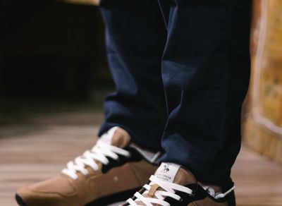 Close-up of athletic shoes on a wooden floor, suggesting stability.
